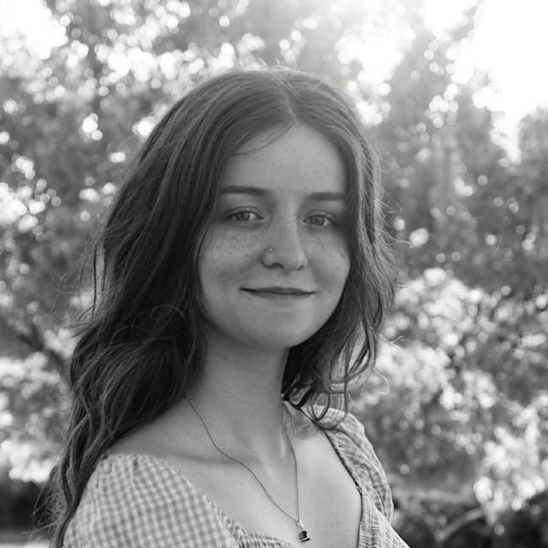 Black and white photo of a woman with long hair in an outdoor setting